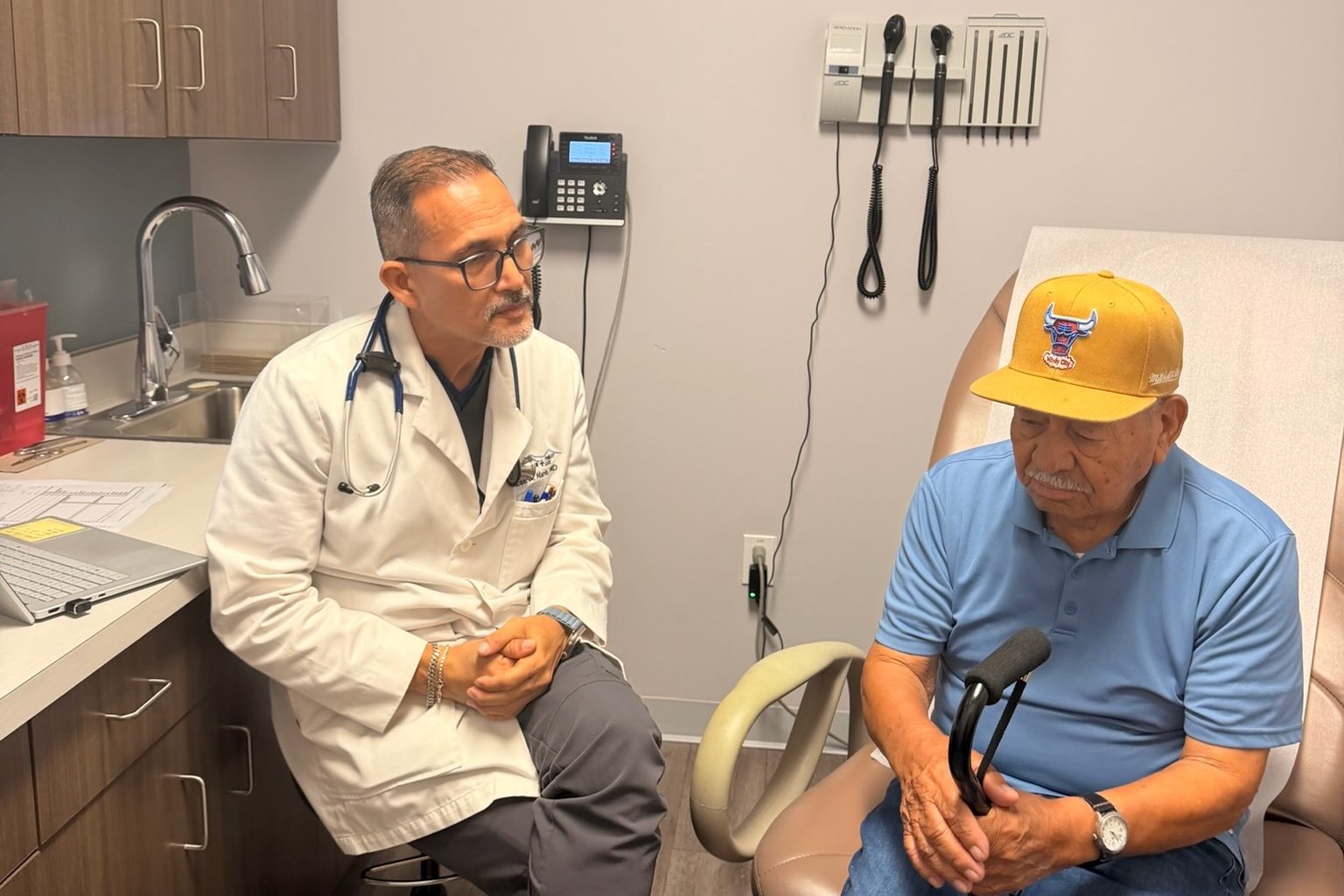 Dr. Jose A. Marin sitting with a patient in an exam room at Transmountain Primary Care