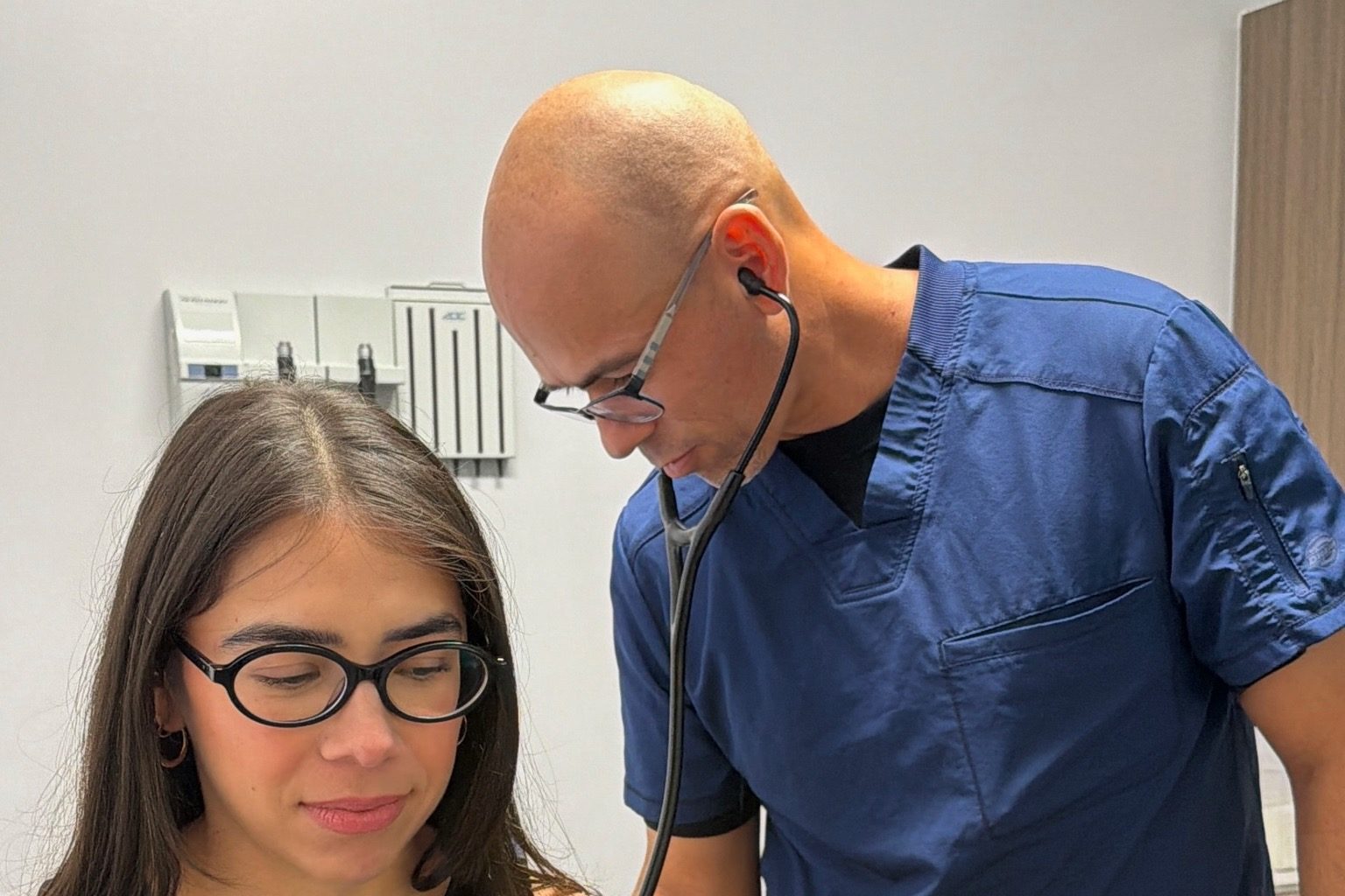 A Transmountain Primary Care provider listening to a patient's breathing during a physical in El Paso