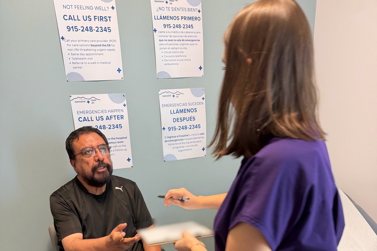 A Transmountain Primary Care team member handing a form to a patient in El Paso
