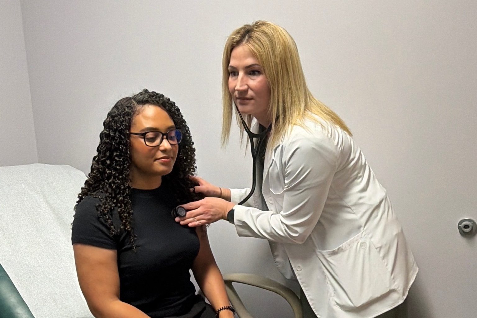 A Transmountain Primary Care provider listening to a patient's heart with a stethoscope in El Paso