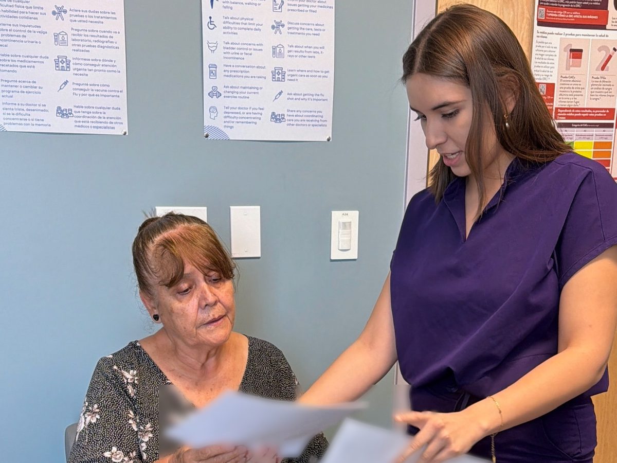 A team member going over paperwork with a patient at Transmountain Primary Care in El Paso