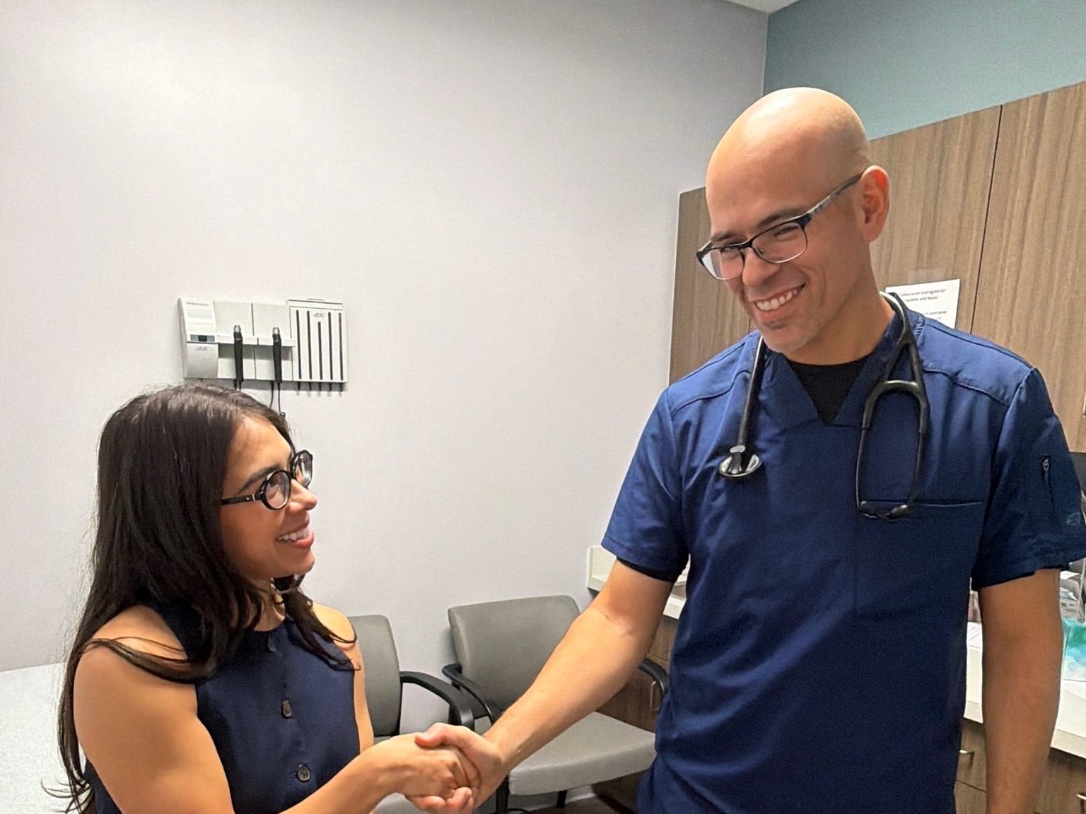 A Transmountain Primary Care provider shaking hands with a patient in an exam room